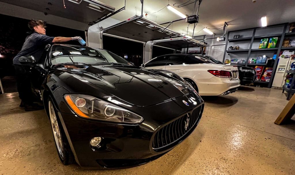 Black Maseratti getting ceramic coating inside a garage